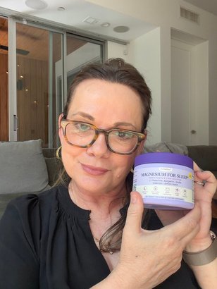 Liz holding a skincare jar at home