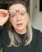 Close-up of Liz adjusting her glasses