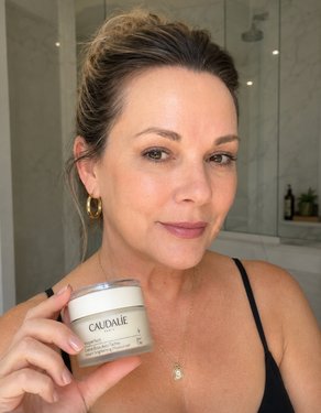 Liz holding a Caudalie skincare product